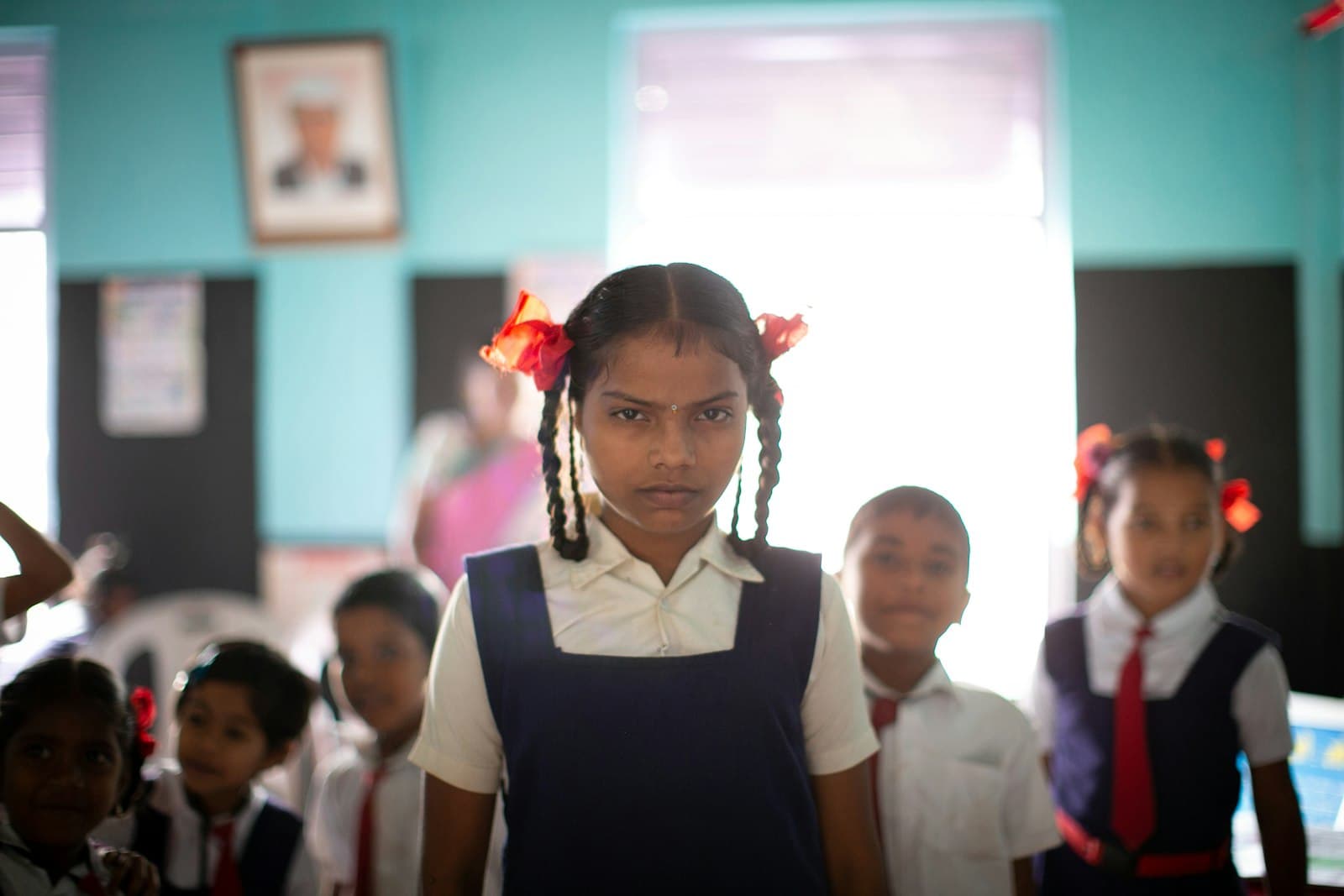 Priya, a schoolgirl in uniform, standing confidently among her classmates in a bright classroom.